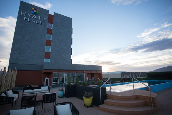 A hotel with a pool area, outdoor seating, and a staircase leading to the pool. - Hyatt Place Saltillo (Saltillo)