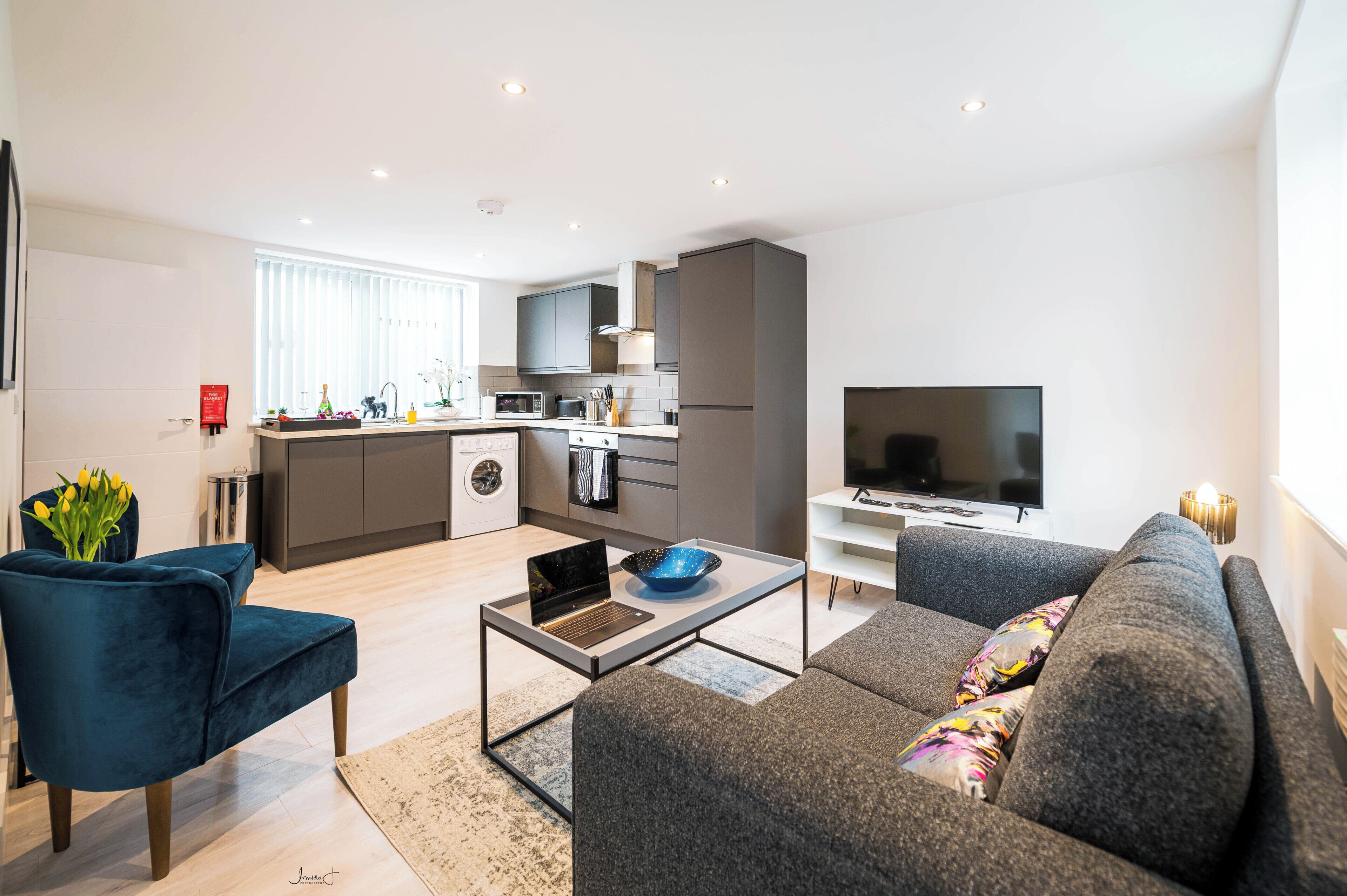 A modern apartment with a kitchen, living area, and a TV.