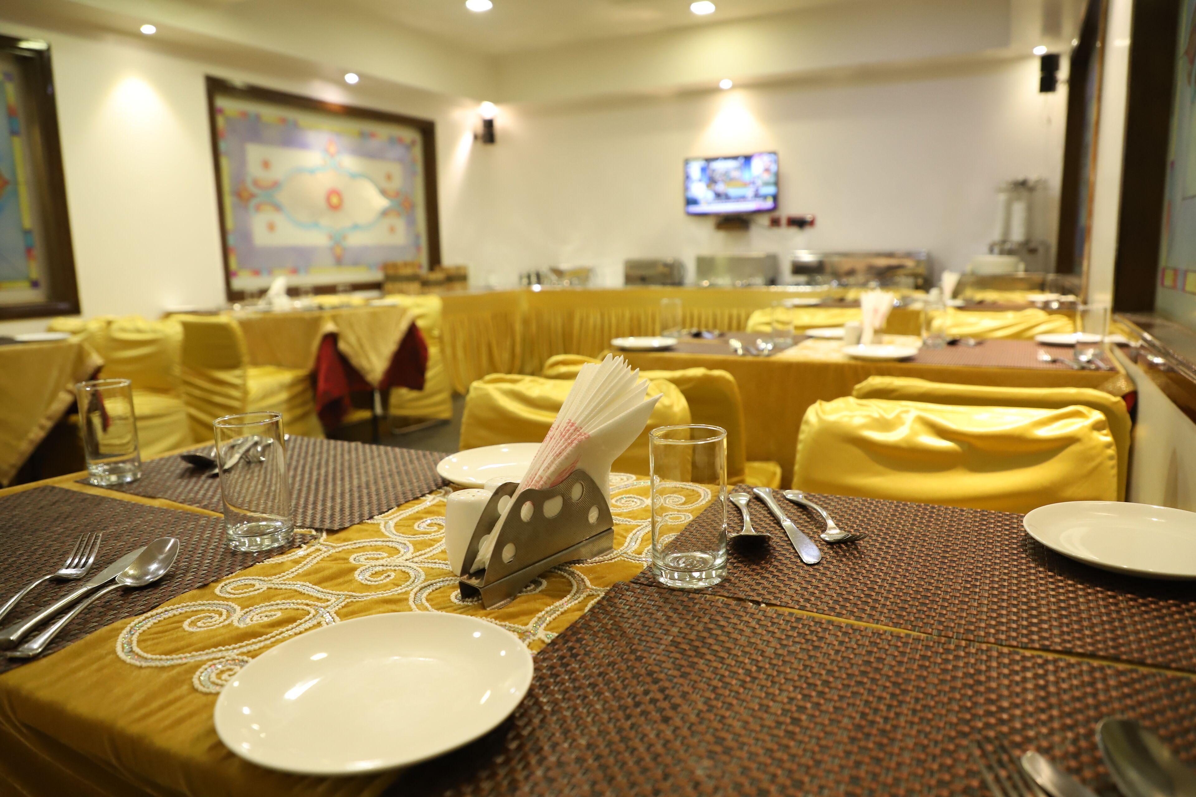 A dining area with tables set for a meal, including plates, cutlery, and glasses.