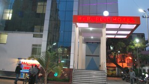 A modern hotel with a glass facade and a red entrance. - Republic Hotel (Patna)