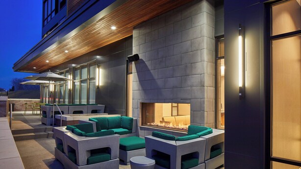 An outdoor seating area with modern furniture and a built-in fire feature.