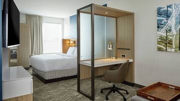 Een hotelkamer met een bed, bureau, stoel en een televisie.