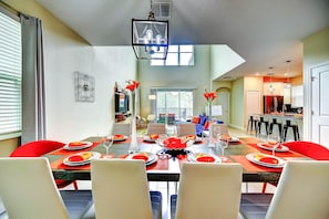 A dining area with a long table set for six, surrounded by chairs. - Secret Cove (Davenport)