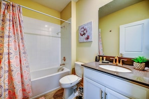 A bathroom with a shower, toilet, sink, and a mirror. - Secret Cove (Davenport)
