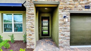A stone facade with a green door and a window. - Secret Cove (Davenport)