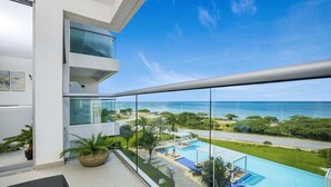 Un balcon offrant une vue dégagée sur une piscine et l’océan.