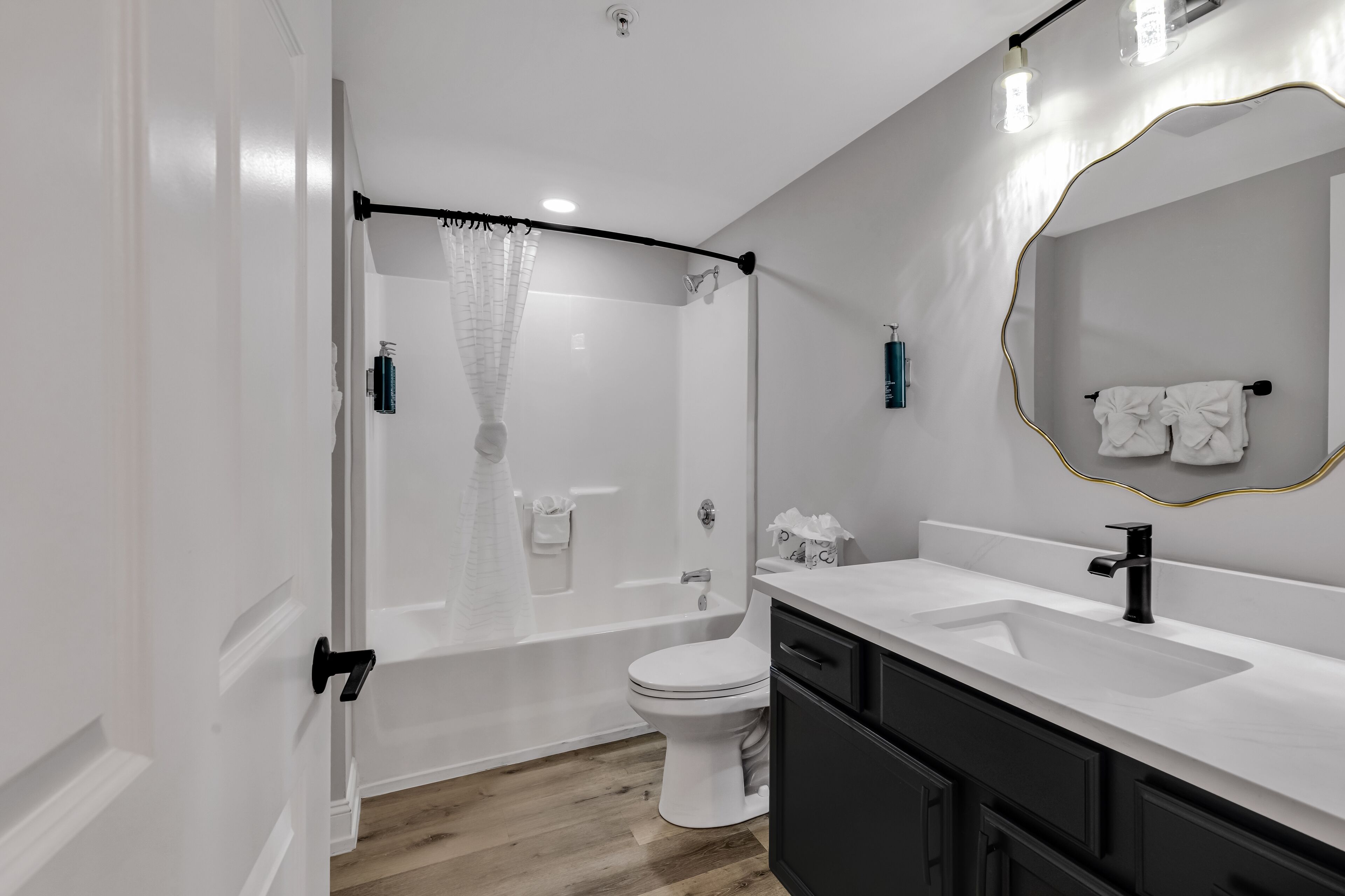 A modern bathroom with a bathtub, toilet, and sink.