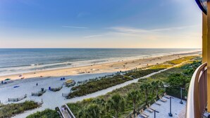 A beach view from a balcony overlooking a sandy beach with a clear sky. - Beachfront Anderson Condos by Hosteeva (Myrtle Beach)