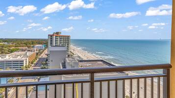 A high-rise hotel with a view of the beach and ocean.