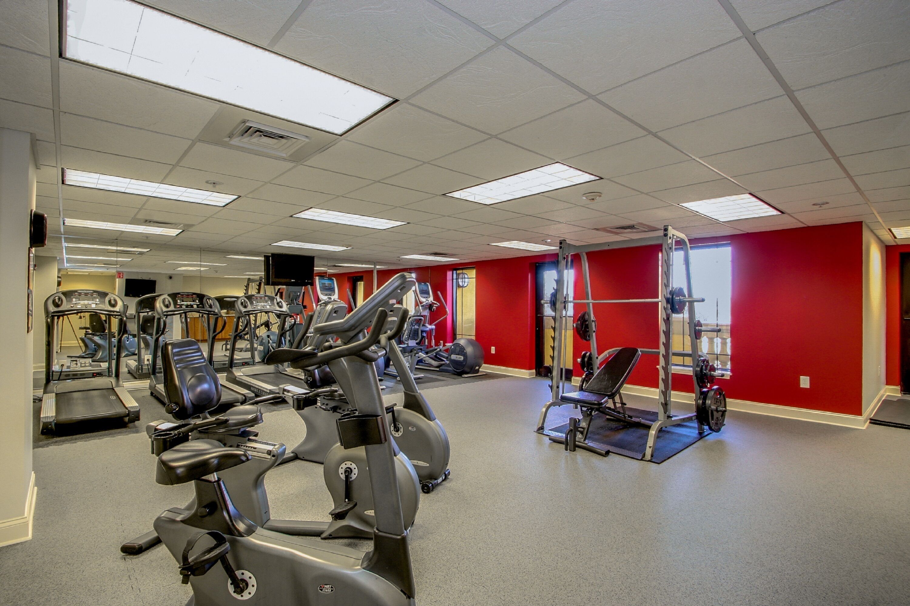 A gym with treadmills, elliptical machines, and weight equipment.