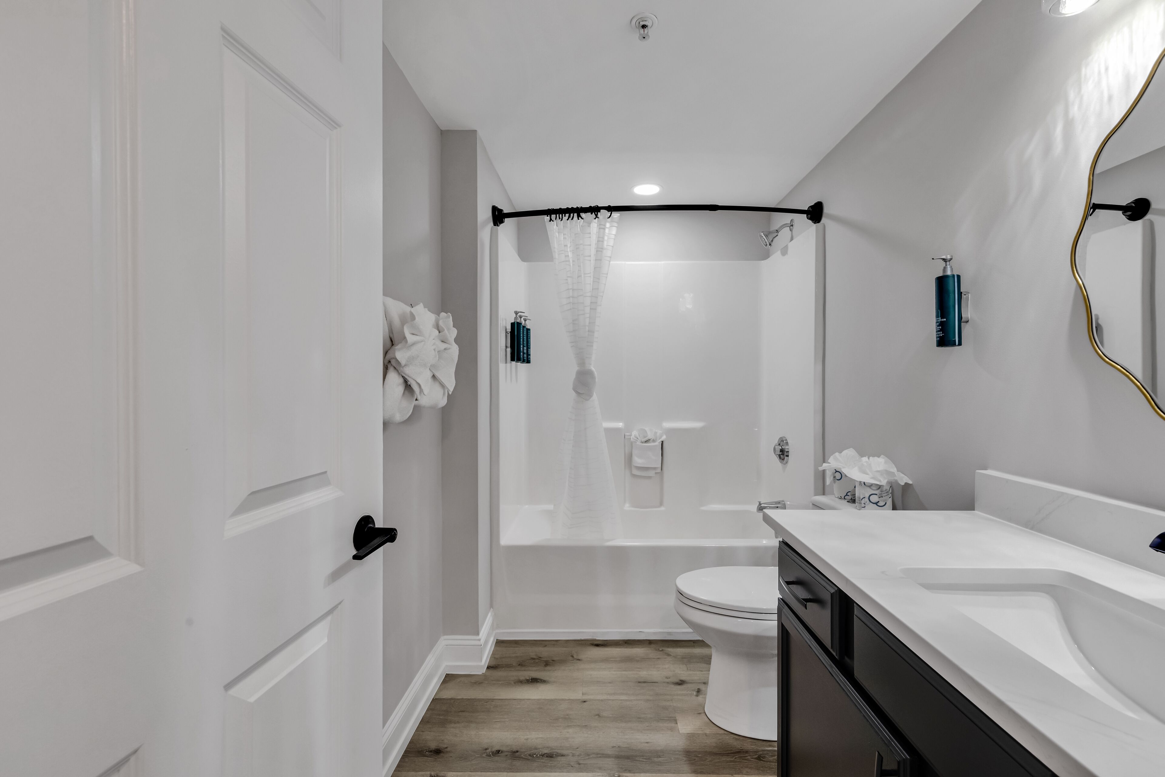 A modern bathroom with a shower, toilet, and vanity.