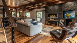 A spacious living room with a large sectional sofa, a fireplace, and a stone accent wall.