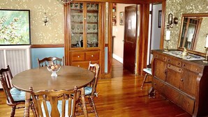 A dining room with a wooden table and chairs, a china cabinet, and a large mirror. - "The In & Out Room" at TPH - Boston (Boston)