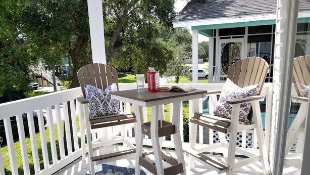 A covered outdoor seating area with white railings and a blue patterned rug. - Island House D : Stylish Updated Townhome - Steps to the Beach w/ Pool! (Surfside Beach)