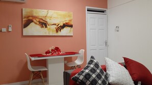Ein Wohnzimmer mit einem roten Sofa, einer weißen Tür und einem Gemälde an der Wand.