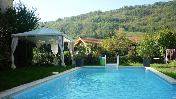 A rectangular swimming pool with a white canopy and a house in the background. - Ground floor apartment 3*** classification (Vaulnaveys-le-Haut)