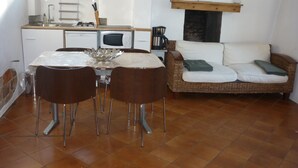 A compact kitchen with a dining table, chairs, a microwave, and a coffee maker. - Ground floor apartment 3*** classification (Vaulnaveys-le-Haut)