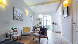 Une chambre d’hôtel moderne dotée d’un coin repas, d’un plancher en bois et d’un balcon avec vue.
