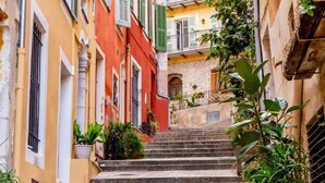 Une rue étroite avec des marches en pierre menant à un bâtiment à la façade en pierre.