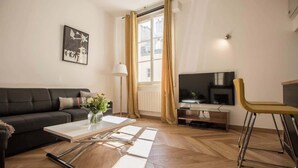 Una sala moderna con un sofá, una mesa de centro, un televisor y una silla.