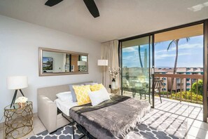 Een hotelkamer met een bed, een groot raam, een balkon en uitzicht op het landschap.