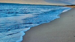 A beach with a clear sky and waves.
