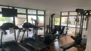 Ein Fitnessstudio mit Laufbändern, Kraftgeräten und Bänken.