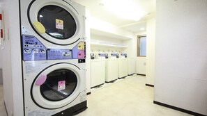 Une laverie équipée de plusieurs machines à laver, d’un panneau de commande et d’un panneau indiquant une durée de cycle de 10 minutes.