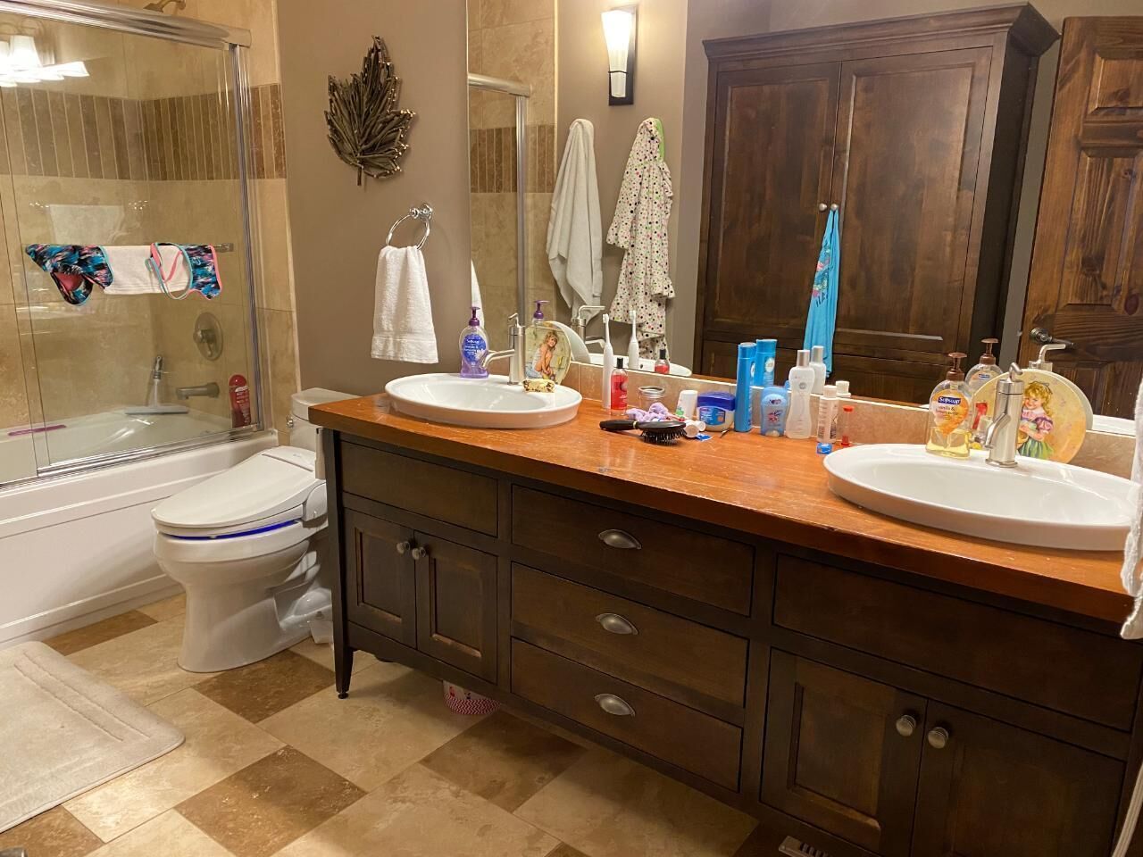 A bathroom with two sinks, a toilet, and a shower.