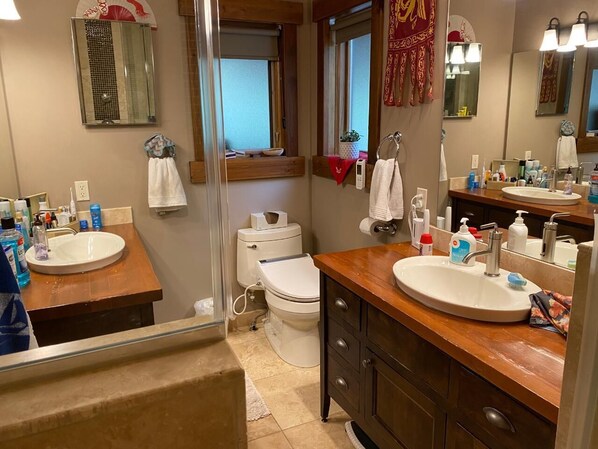 Un baño con dos lavamanos, un inodoro y una ducha.