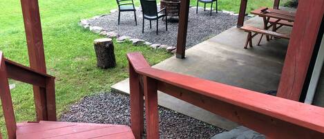A wooden deck with a red railing leading to a covered patio area.