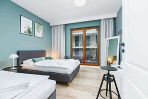 Relax in a serene space with a large bed, framed artworks, and a sliding door to an outdoor area.