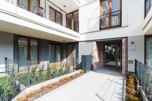 Stylish building with a glass and brick facade, featuring large windows and a secure metal fence.