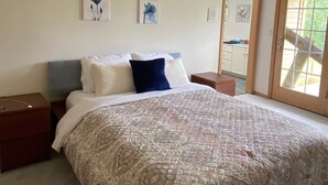 Un dormitorio con una cama grande, un ventilador de techo y obras de arte en la pared.