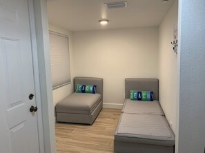 Two single beds with matching headboards and a bench-like seating area.