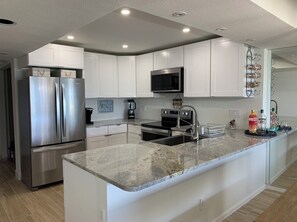 Enjoy cooking in this fully equipped kitchen with a refrigerator, microwave, and range hood.