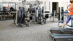 Un gimnasio con cintas de correr, máquinas de pesas y mancuernas.