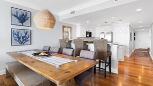 A spacious dining area with a wooden table, cushioned chairs, and a woven pendant light. -  GULF FRONT on 30A with Beach setup! (Santa Rosa Beach)