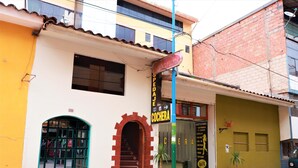 A building with a storefront labeled "COCHERA" and a sign for "SPEDAL". - Hospedaje Don Juan (Cusco)