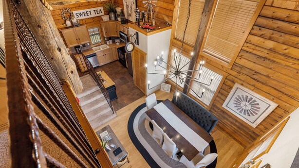 Interior acogedor de una cabaña con comedor, cocina y una escalera.