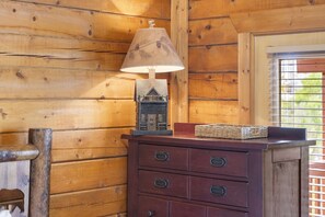 A cozy space with a dresser, lamp, and decorative house-shaped object.