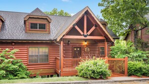 A log cabin with a porch, a small window, and a door. - Lovely Log Cabin with Whirlpool Tub in Branson Theatre District (Branson)