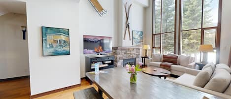 Relax in this cozy living space with a fireplace, large windows, and comfortable seating.
