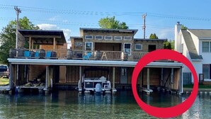 A houseboat with a covered deck and a garage. - Torch Lake Sandbar Directly Across the Street With Indoor Boat Slip Unit A (Rapid City)