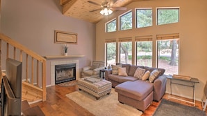 A spacious living room with a fireplace, wooden ceiling, large windows, and a cozy seating area. - Forest-View Retreat in Payson, Close to Hiking! (Payson)
