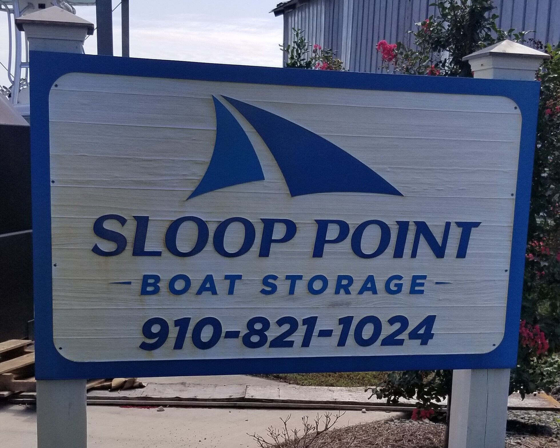 Señal de Sloop Point Boat Storage, número de contacto 910-821-1024.