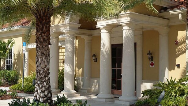 A building with a classical architectural style, featuring columns and a covered entrance. - Warmth and harmony await you. (Bonita Springs)
