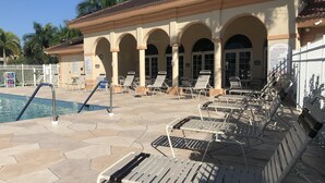 Zona de piscina con sillones de descanso y una piscina.