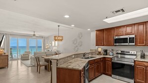Una cocina moderna con encimeras de granito, electrodomésticos de acero inoxidable y armarios de madera.