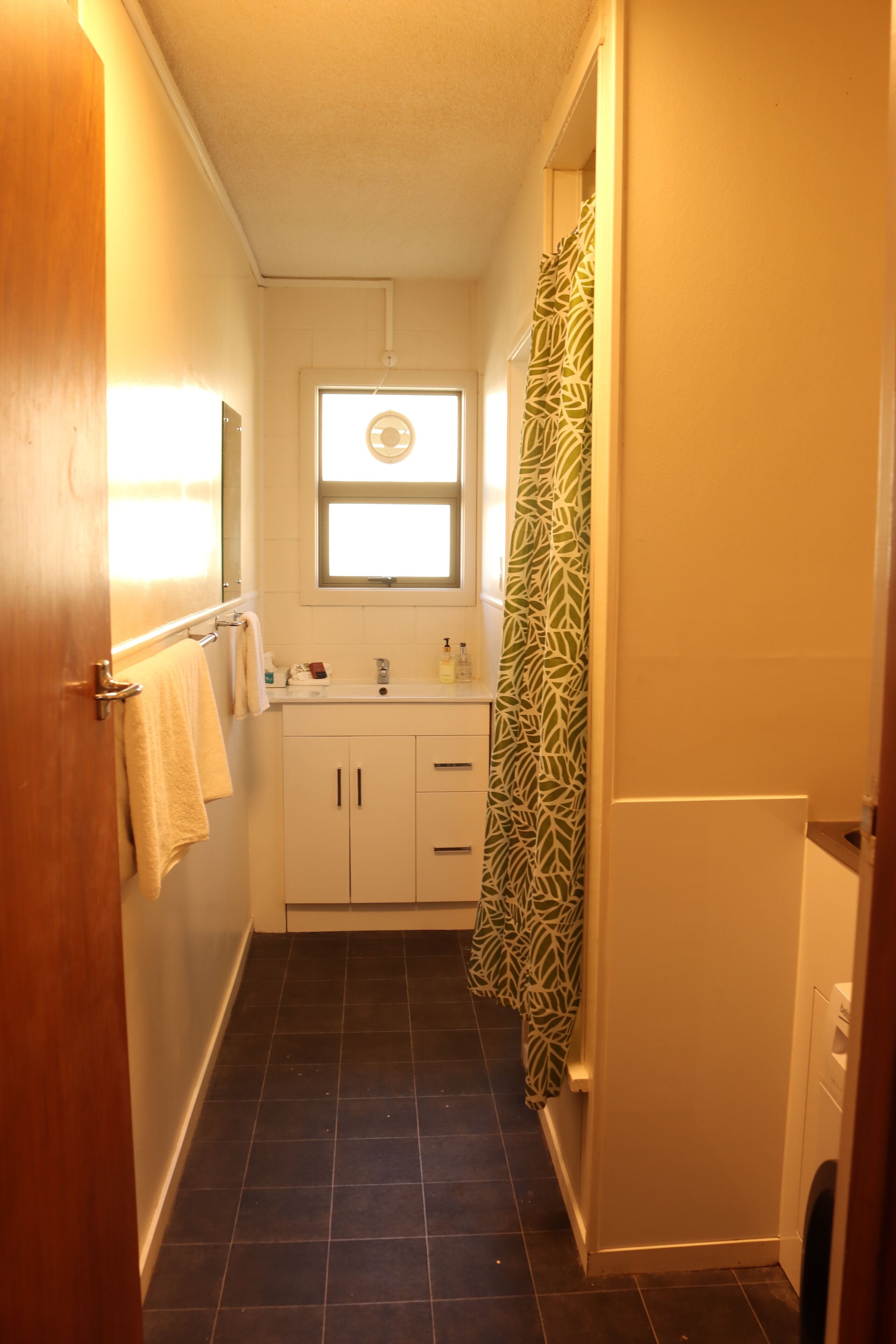 Une petite salle de bain avec une fenêtre, un lavabo et des toilettes.